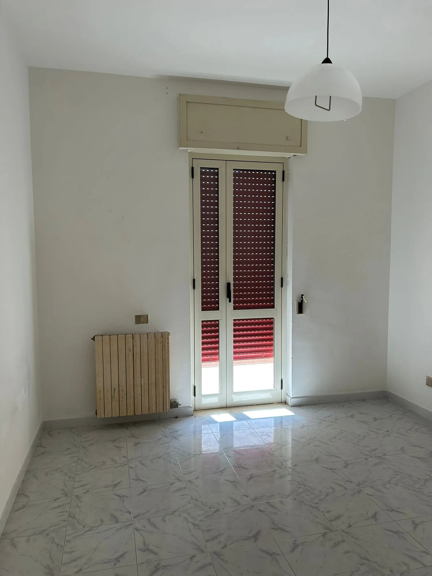 Room before the works, with terrazzo floor and old radiator