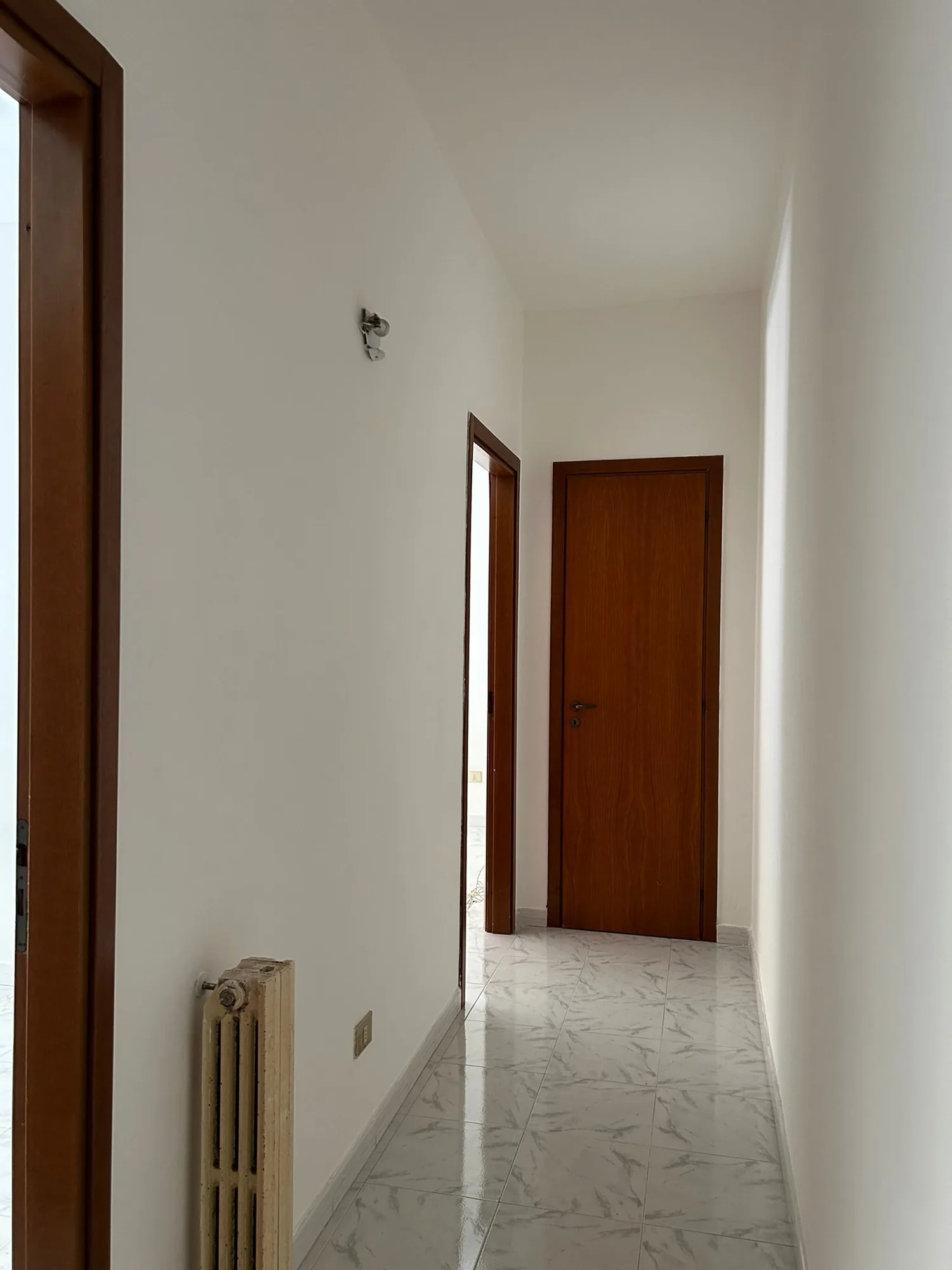 Hallway with wooden door, in the previous layout of the apartment