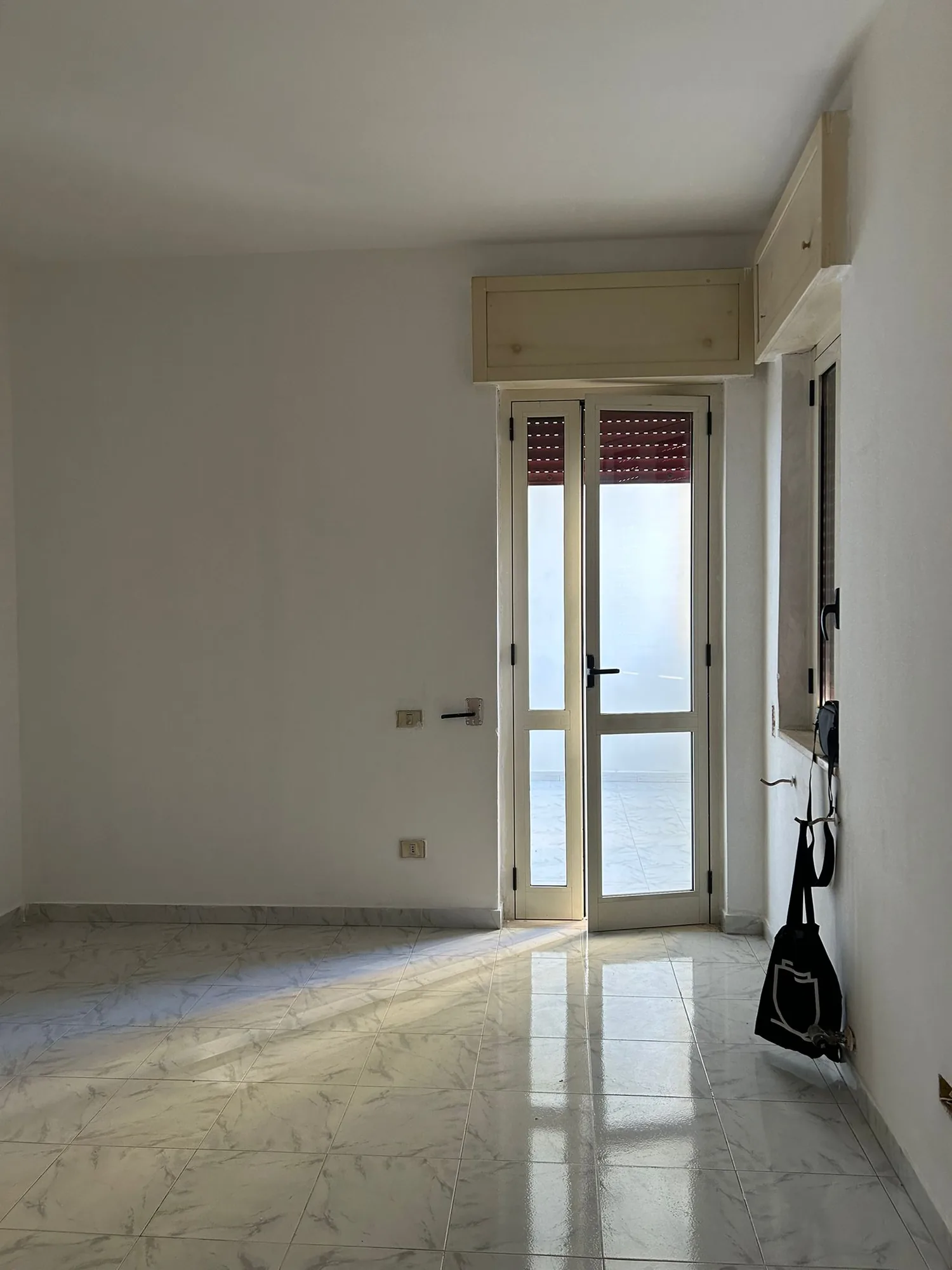 Empty room before construction, with original fixture and polished floor