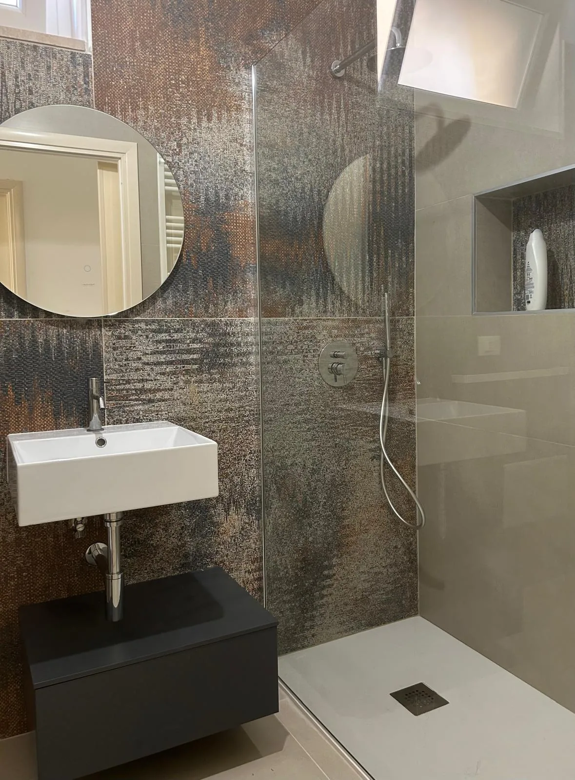 Finished bathroom, with dark material covering and floor-level shower
