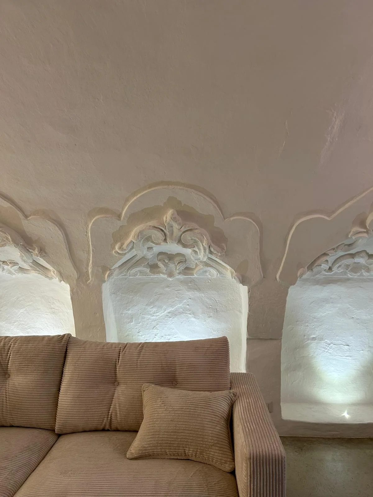 The sofa placed next to the stucco-decorated wall, once the work has been completed