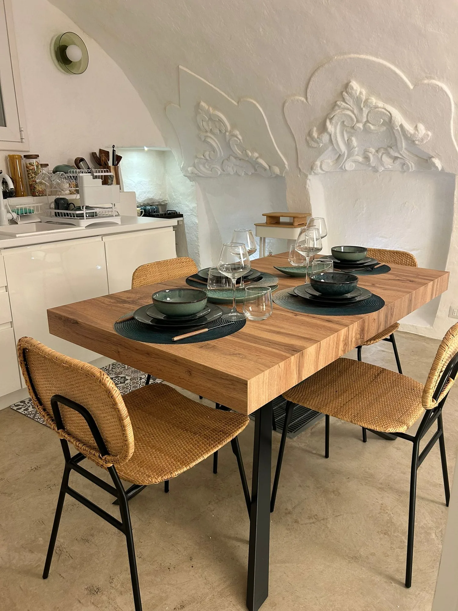The wooden table in the dining area, under the recovered stucco