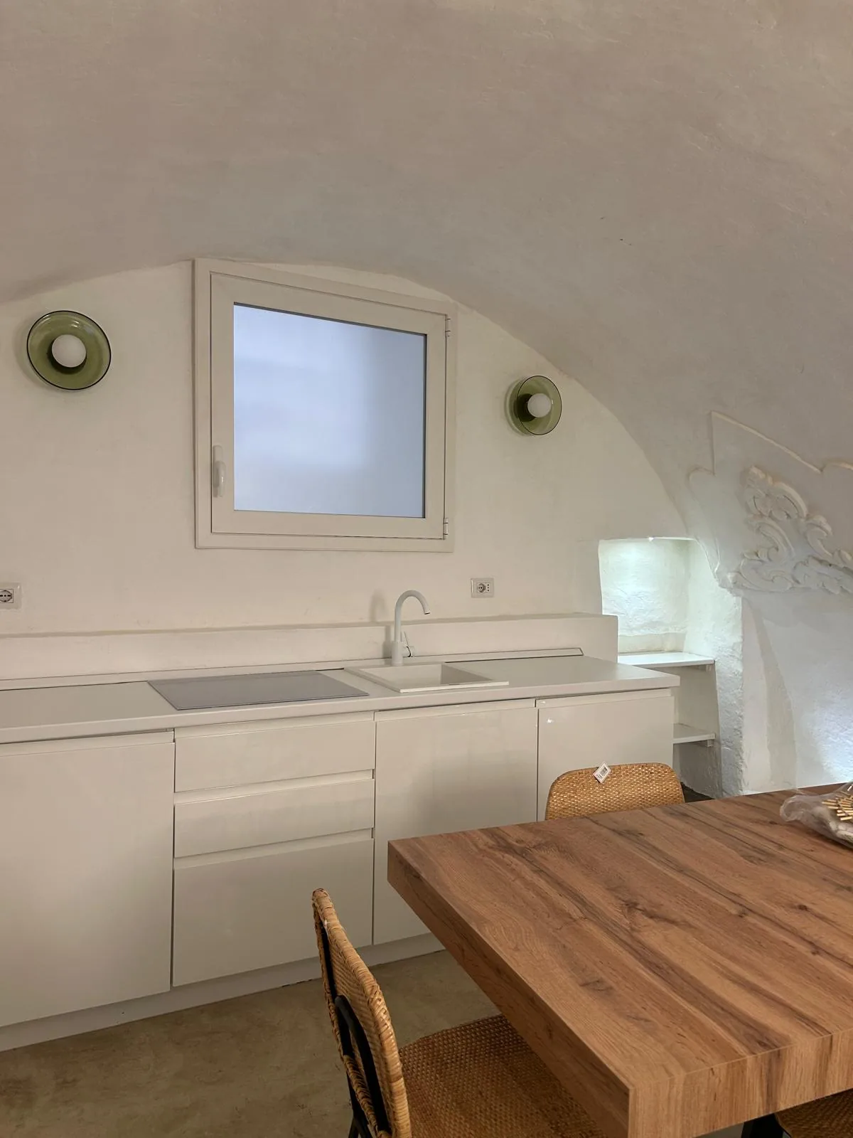 The linear white kitchen under the lowered vault