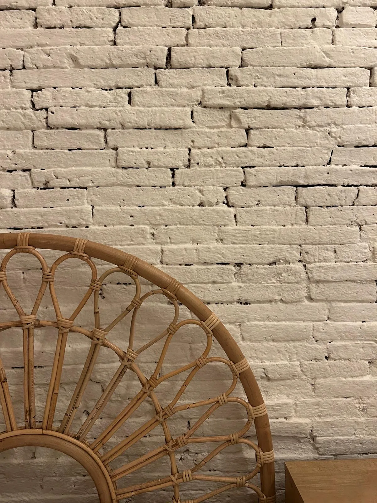 Detail of the whitewashed brickwork with rattan seat
