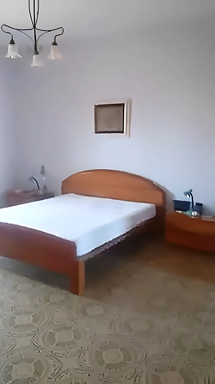 Camera da letto prima dei lavori, con letto in legno, comodini e applique a parete