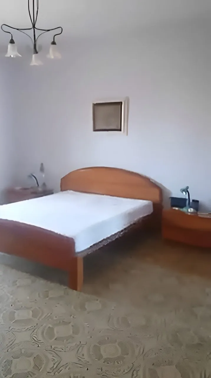 Bedroom before the renovation, with wooden furnishings and designed flooring