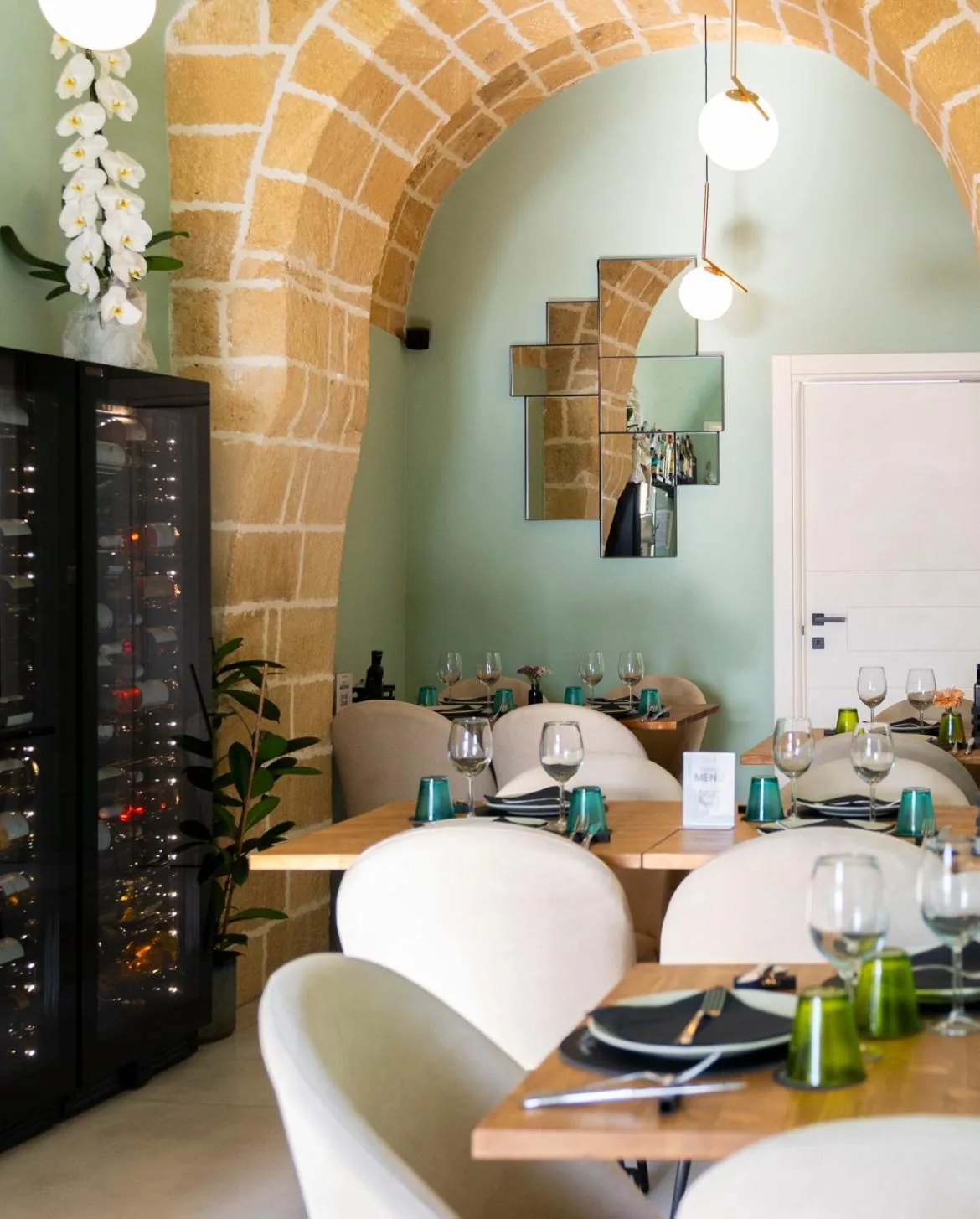 The finished room, with exposed stone arch and tables under the vault