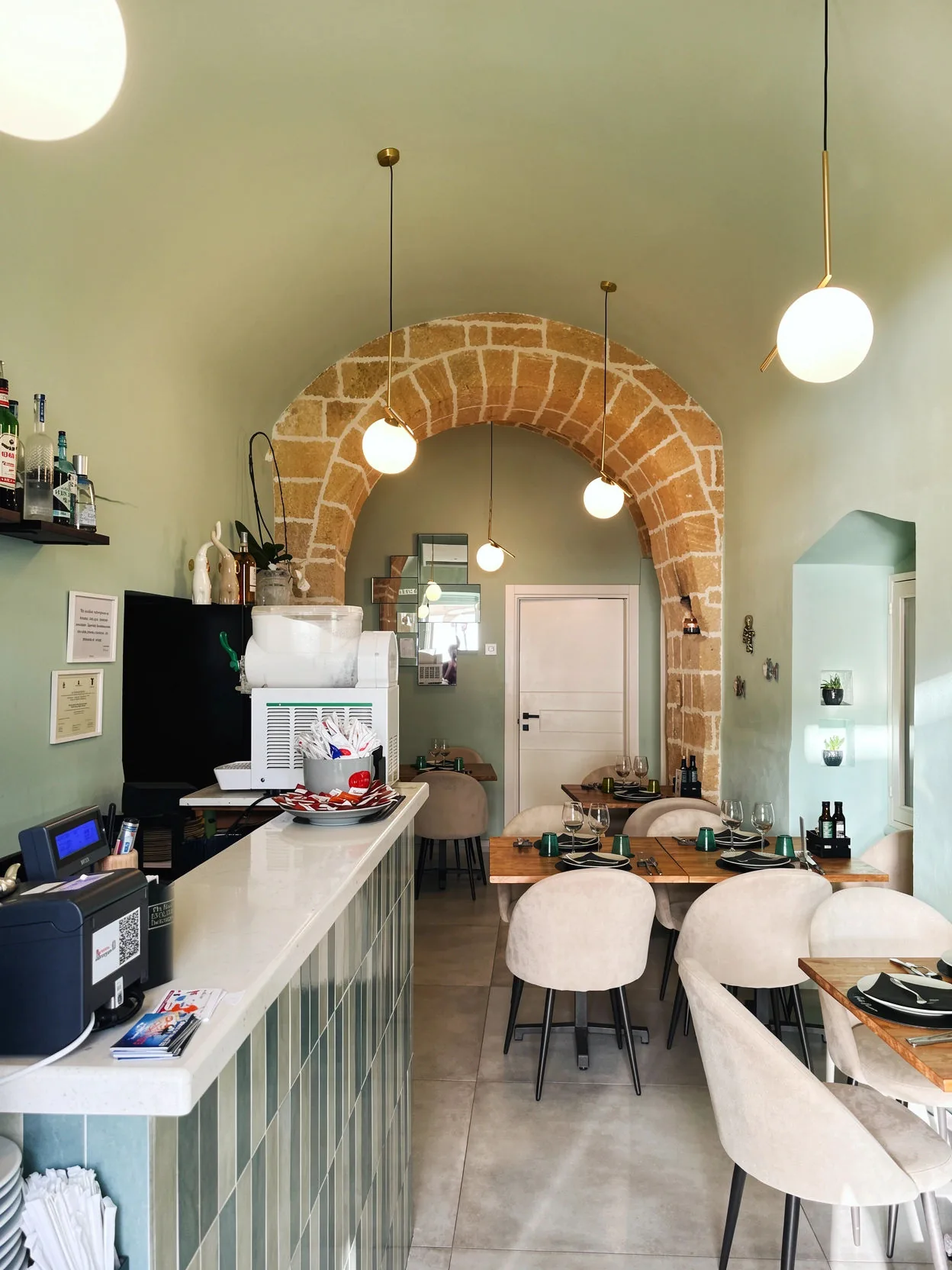 View of the room towards the counter, with light seats and sphere lamps
