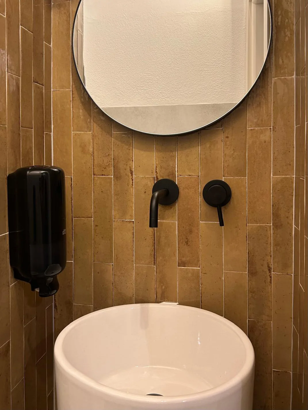 The bathroom redone, with yellow cladding and black taps