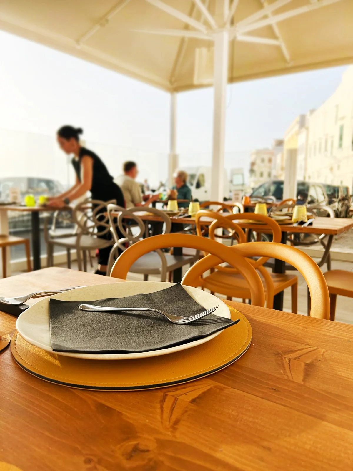The outdoor space on the Spiaggia della Purità, with umbrellas and set tables