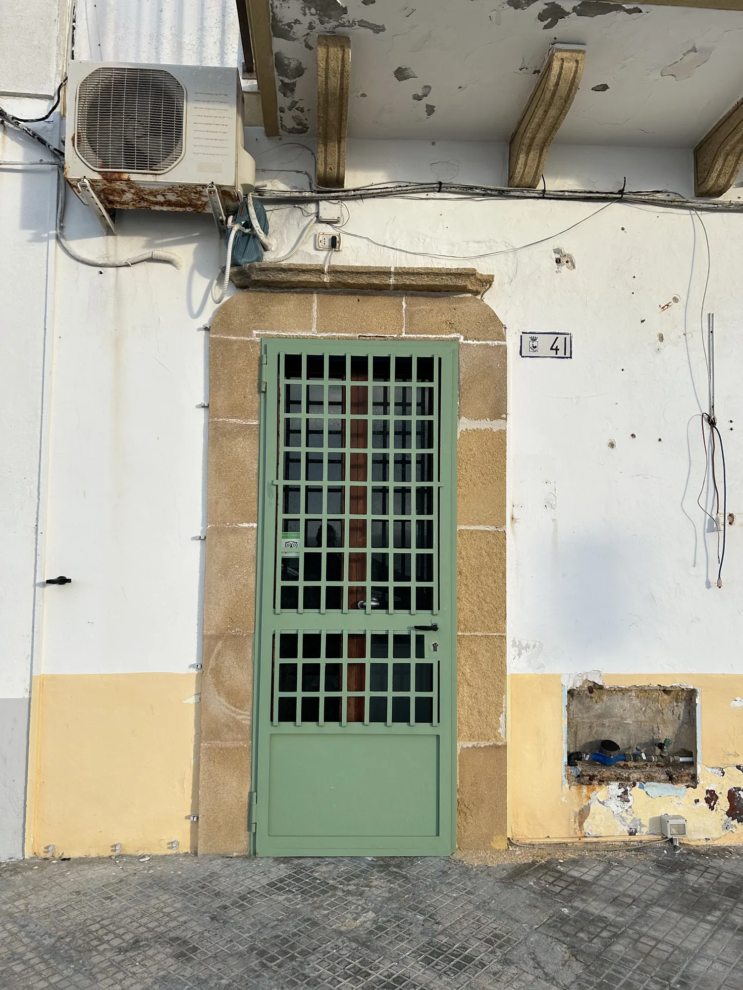 The facade before the works, with iron door and deteriorated plaster